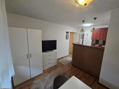 a living room with a television and a kitchen at Apartman Sanus in Sanski most