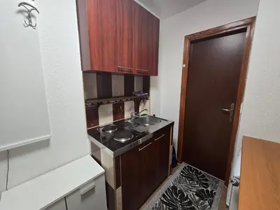 a small kitchen with a stove and a sink at Apartman Sanus in Sanski most