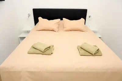 a bed with two pillows and two towels on it at Apartman Leo Jajce in Jajce