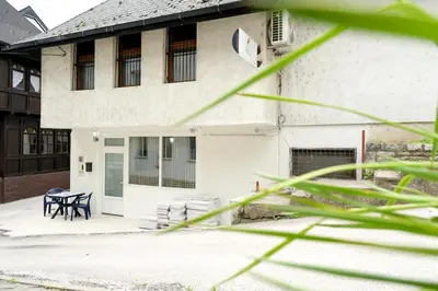 a white house with a table and a bench at Apartman Leo Jajce in Jajce