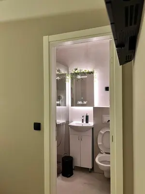 a bathroom with a toilet and a sink and a mirror at Apartmani Mila Mi in Kotor-Varoš