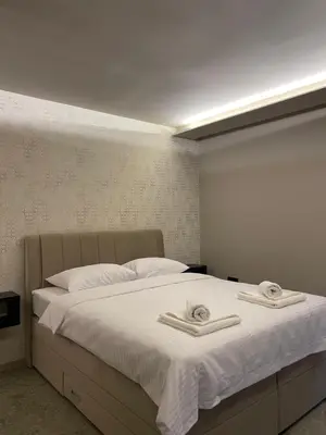 a bedroom with a bed with two towels on it at Apartmani Mila Mi in Kotor-Varoš