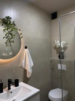 a bathroom with a sink and a toilet and a mirror at Apartmani Mila Mi in Kotor-Varoš