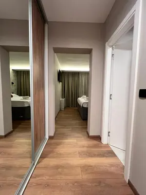 a hallway with a room with a bed and a mirror at Apartmani Mila Mi in Kotor-Varoš