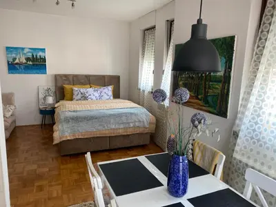 a bedroom with a bed and a table with a vase at Apolon I Apartment in Banja Luka