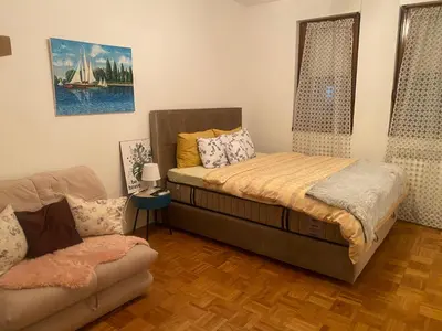 a bedroom with a bed and a couch at Apolon I Apartment in Banja Luka