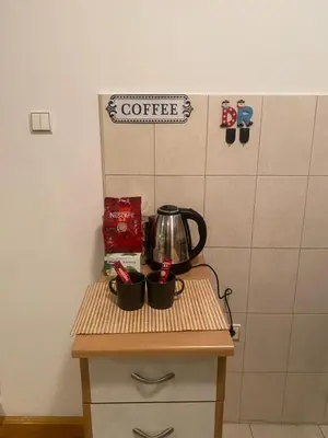 a table with two cups and a coffee pot on it at Apolon I Apartment in Banja Luka