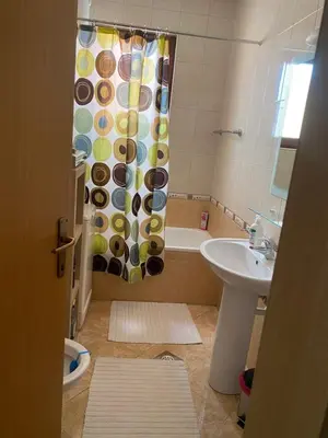 a bathroom with a shower curtain and a sink at Apolon I Apartment in Banja Luka