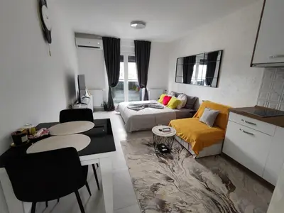 a living room with a couch and a table at Apartman BULEVAR1 sa garažom in Doboj