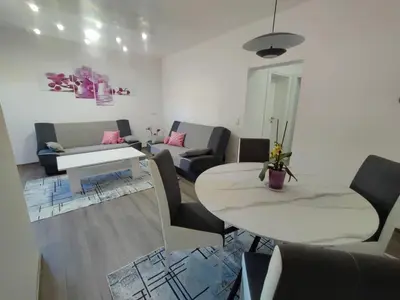 a living room with a couch and a table at Apartman Orhideja in Bihać