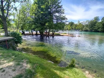 a view of a lake with trees in the water at Apartman Orhideja in Bihać