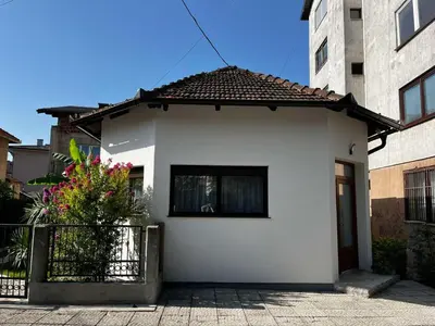 a white house with a black fence in front of it at Apartman Orhideja in Bihać