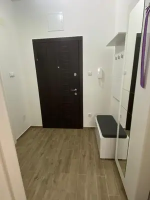 a bathroom with a black door and a wooden floor at Apartman Ema in Banja Luka