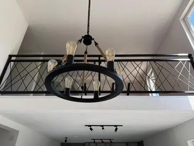 a black chandelier hanging from a ceiling with wine glasses at Villa Maglić Vlašić in Vlasic