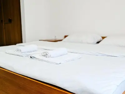 two beds with white sheets and towels on them at Motel Dačo in Stara Bila