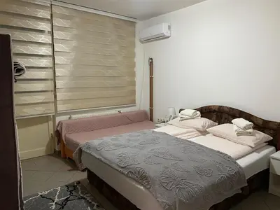 two beds in a room with a window at Apartmani Alejna in Sanski most