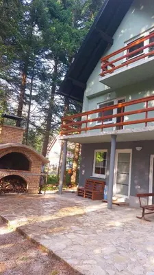 a large house with a patio and a fire place at Kuća za odmor Carpe Diem in Bosanski Petrovac