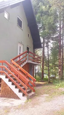 a house with a red staircase on the side of it at Kuća za odmor Carpe Diem in Bosanski Petrovac