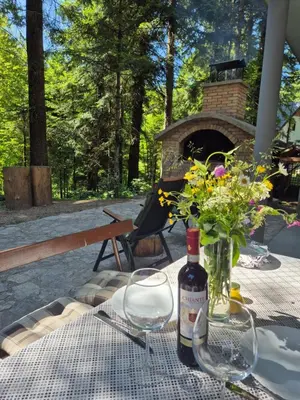 a table with a bottle of wine and flowers on it at Kuća za odmor Carpe Diem in Bosanski Petrovac