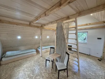 a room with two bunk beds and a table and chairs at Kuća za odmor Carpe Diem in Bosanski Petrovac