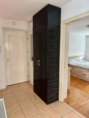 a black closet in a room with a bed at Andjelka apartman in Modriča