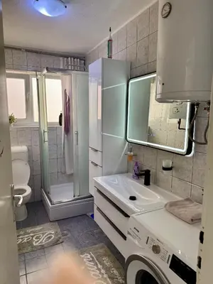 a bathroom with a sink and a washing machine at Andjelka apartman in Modriča