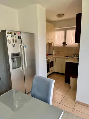 a kitchen with a stainless steel refrigerator and a blue chair at Andjelka apartman in Modriča