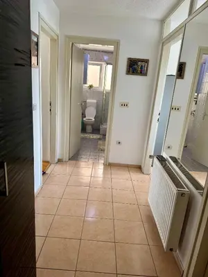 a hallway with a tile floor and a bathroom at Andjelka apartman in Modriča