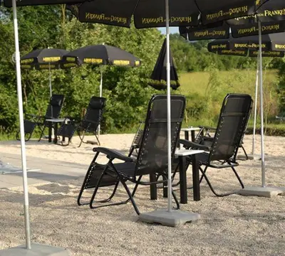 a group of chairs and tables under an umbrella at Apartmani SIMIĆ in Doboj