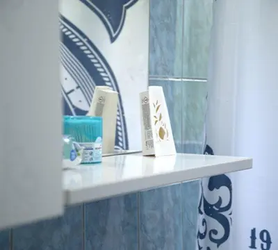 a white shelf in a bathroom with a mirror at Apartmani SIMIĆ in Doboj