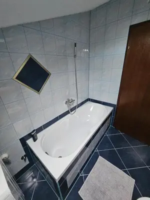 a bath tub in a bathroom with blue tiles at Villa Voljička in Trnovača