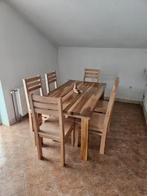 a wooden dining room table with four chairs at Villa Voljička in Trnovača