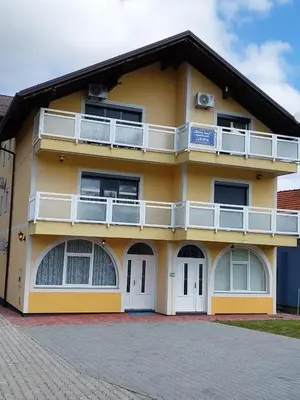 a yellow building with white windows and balconies at Urban home apartments in Bihać