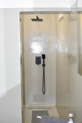 a shower stall with a phone on the wall at Urban home apartments in Bihać