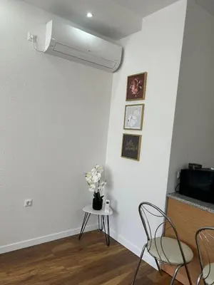 a room with a table with a vase of flowers on it at Urban home apartments in Bihać