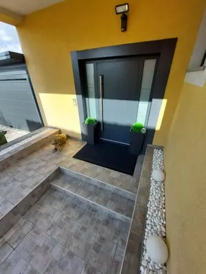 a front door of a house with two potted plants at Urban home apartments in Bihać