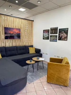 a living room with a blue couch and a table at Apartman ROYAL in Sanski most