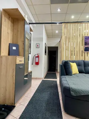 a living room with a blue couch in a room at Apartman ROYAL in Sanski most