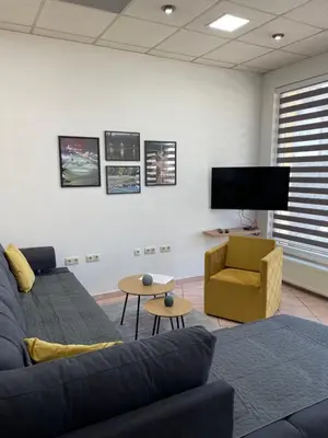 a living room with a couch and a chair and a tv at Apartman ROYAL in Sanski most