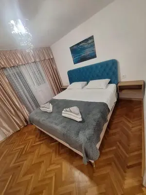 a bedroom with a bed with a blue headboard at URBAN apartment Banja Luka in Banja Luka