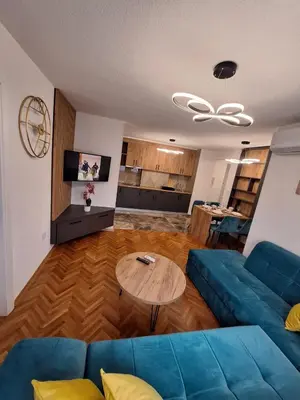 a living room with a blue couch and a table at URBAN apartment Banja Luka in Banja Luka