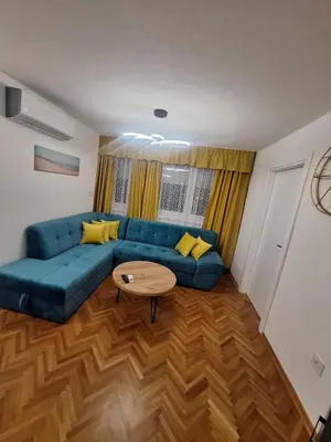 a living room with a blue couch and a table at URBAN apartment Banja Luka in Banja Luka