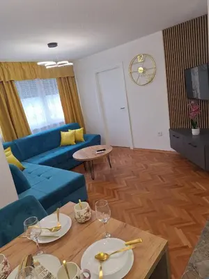 a living room with a blue couch and a table at URBAN apartment Banja Luka in Banja Luka