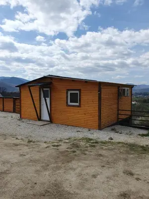 a small wooden cabin with a door on a field at Blanca 6 in Nova Bila