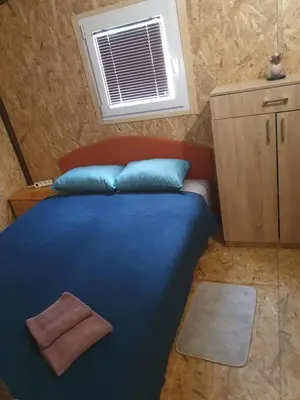 a bedroom with a bed with blue pillows and a window at Blanca 6 in Nova Bila