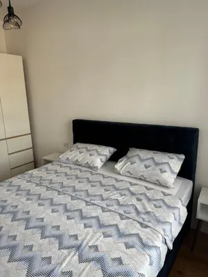 a bed with two pillows on top of it at Stan na dan Apartman Harmonija in Zalužani
