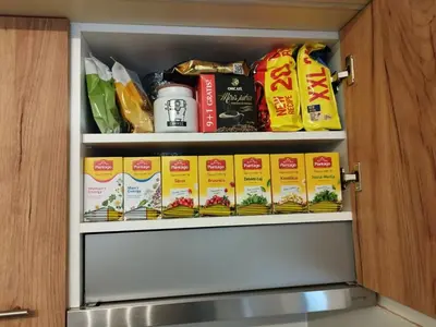 a cupboard filled with lots of food at Stan na dan Apartman Harmonija in Zalužani