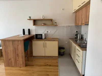 a small kitchen with a desk and a microwave at Stan na dan Apartman Harmonija in Zalužani