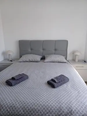 a bed with two towels on it with two lamps at Hilandar in Teslić