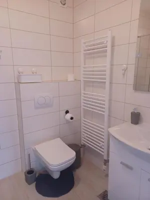 a white bathroom with a toilet and a sink at Hilandar in Teslić
